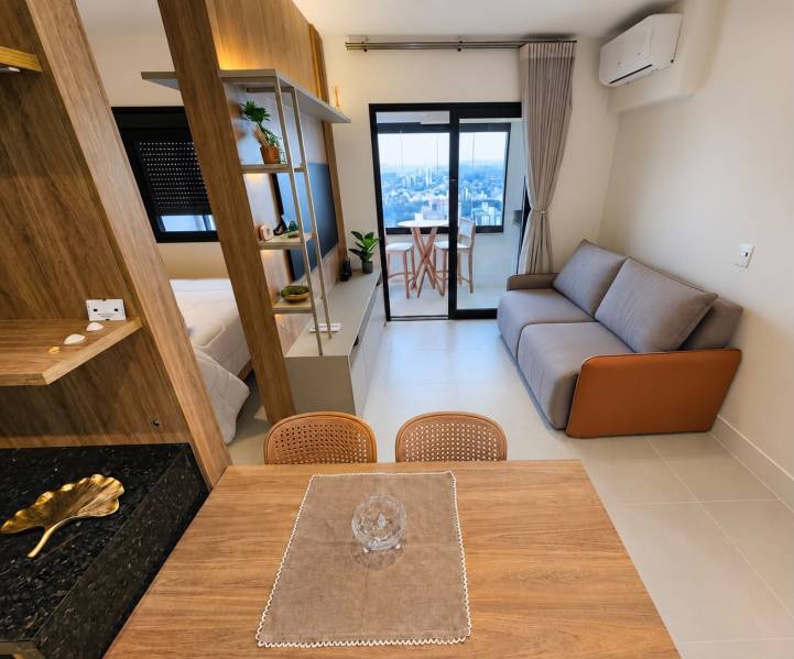 Sala do apartamento mobiliado à venda em Campinas no Sirius Patriani com sofá, jantar integrado e acesso à varanda