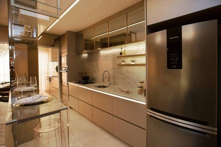 Cozinha do apartamento decorado com bancada e mesa de jantar