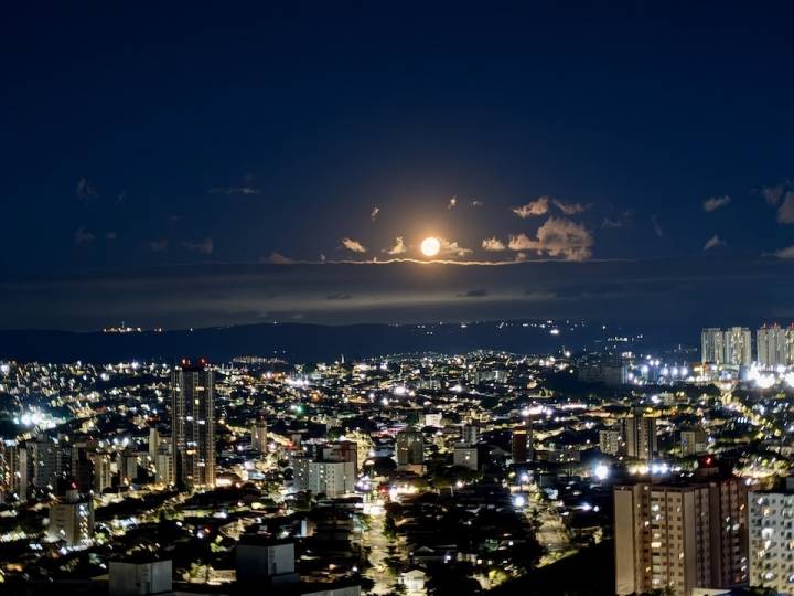 Vista noturna de Campinas com lua no horizonte a partir do apartamento mobiliado no Sirius Patriani